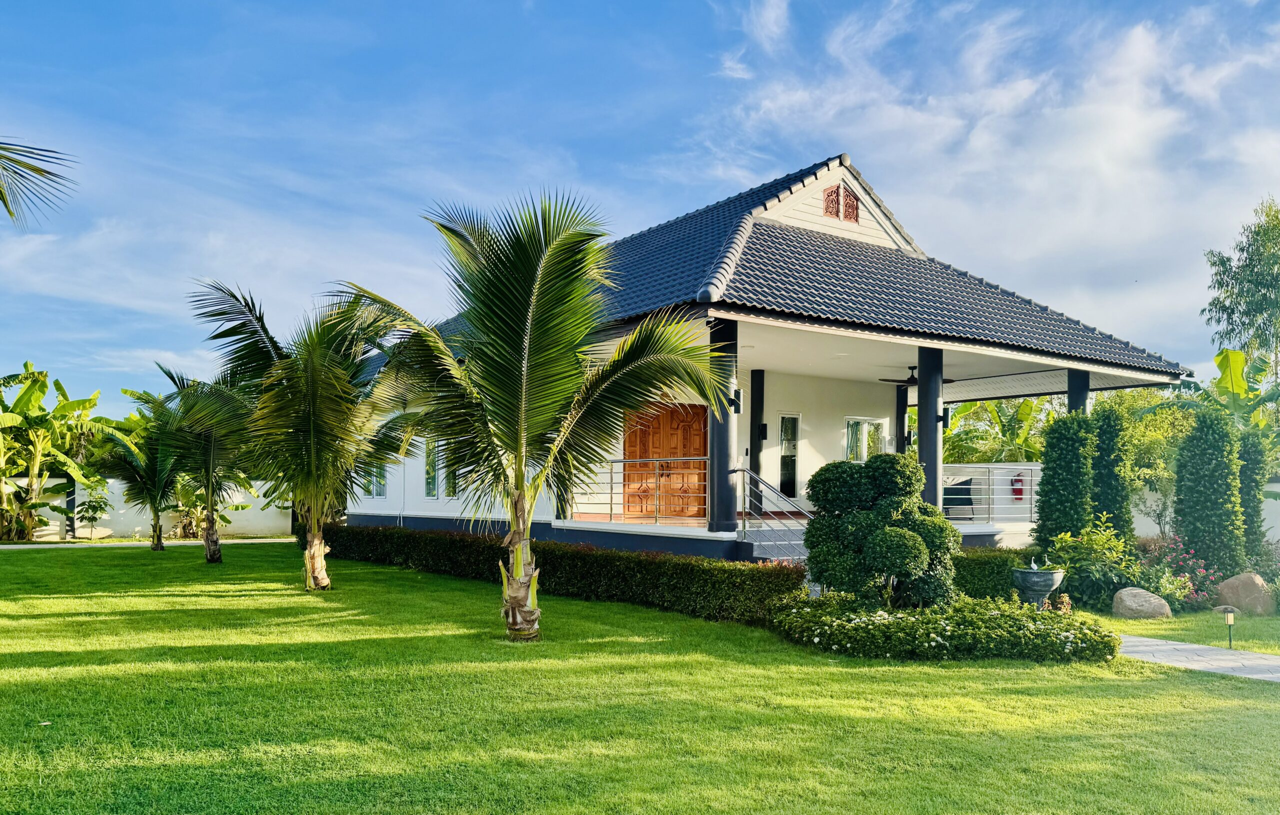 Image of one of our private villas, showing the terrace as well as the surrounding palm trees